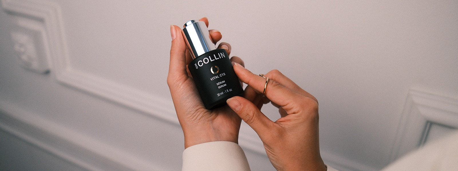 G.M. COLLIN serum in palms against the background of a bead bag